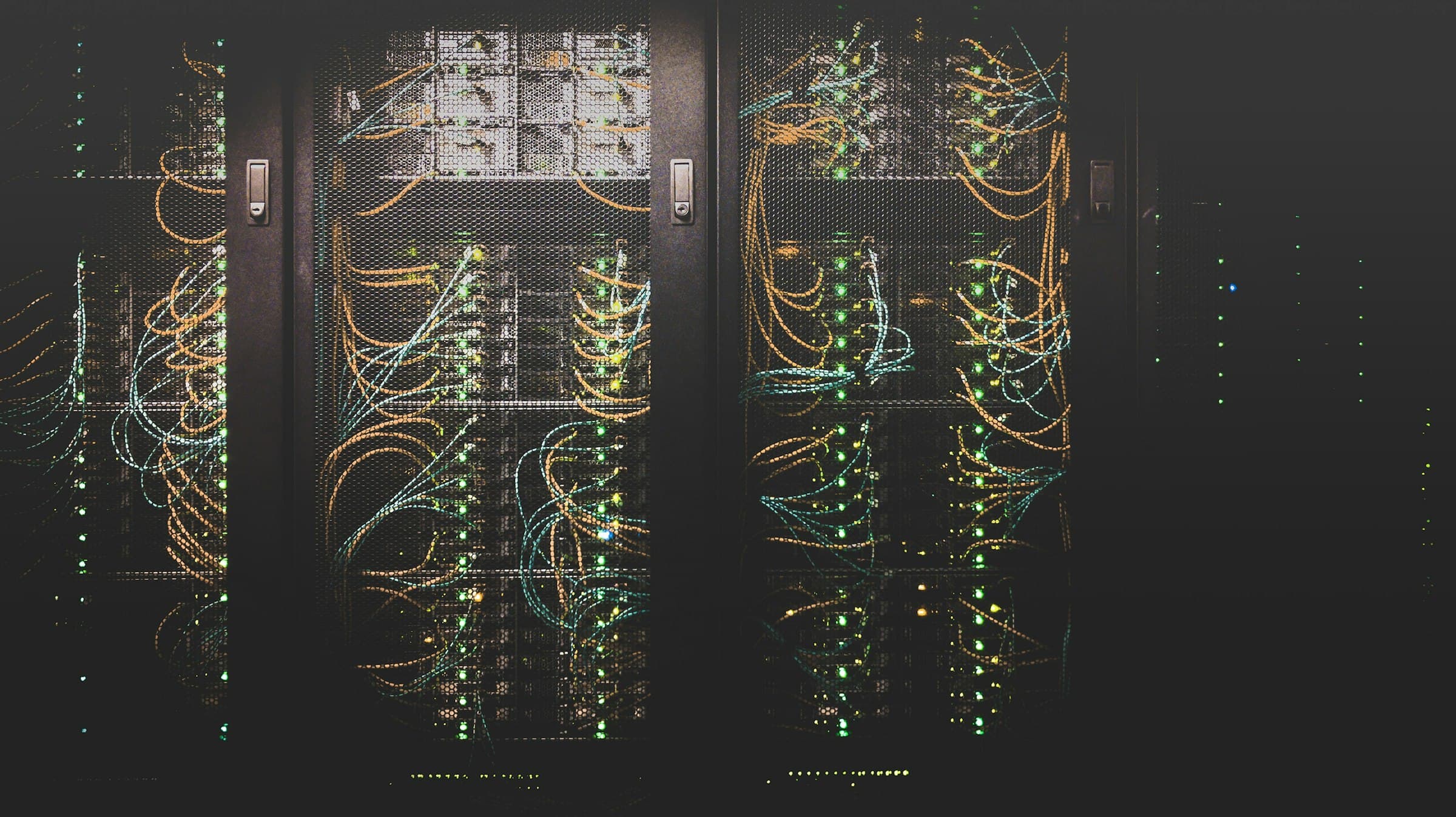 Dark server racks with cabling behind mesh doors